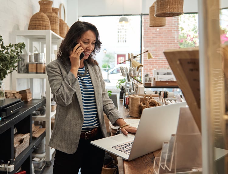 Un propietario de una pequeña empresa está trabajando y usando el teléfono