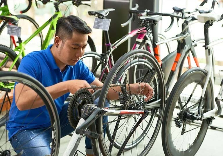 empleado repara una bicicleta en una tienda de bicicletas