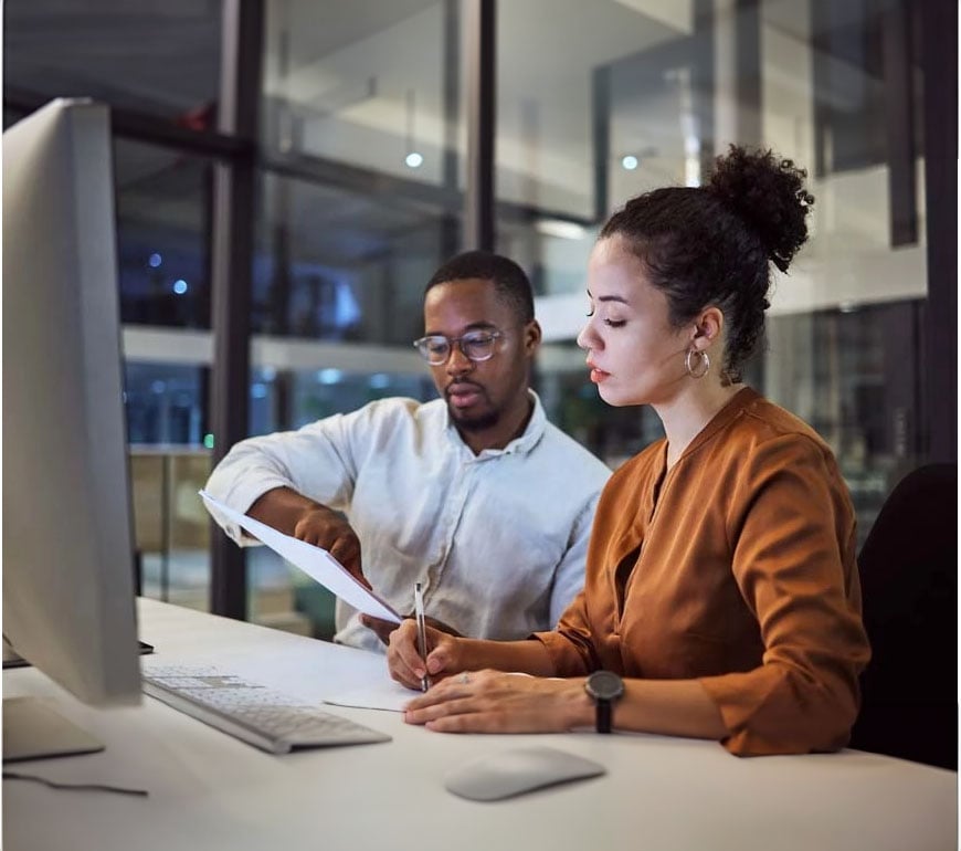 dos personas trabajando en un escritorio