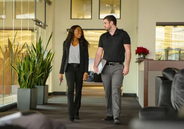 Dos empleados de Paychex caminando por el vestíbulo de una oficina