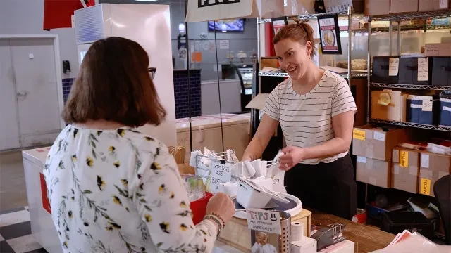 La propietaria Erica Pietrzyk ayuda a un cliente en su tienda de pierogi.
